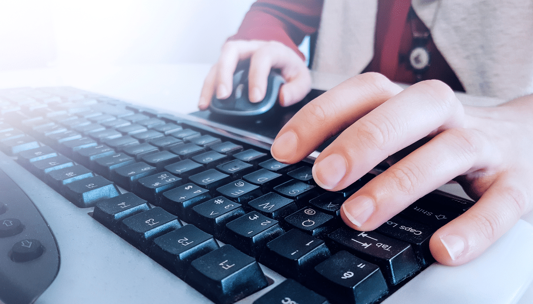 zoom sur clavier, personne qui ecrit et tient une souris